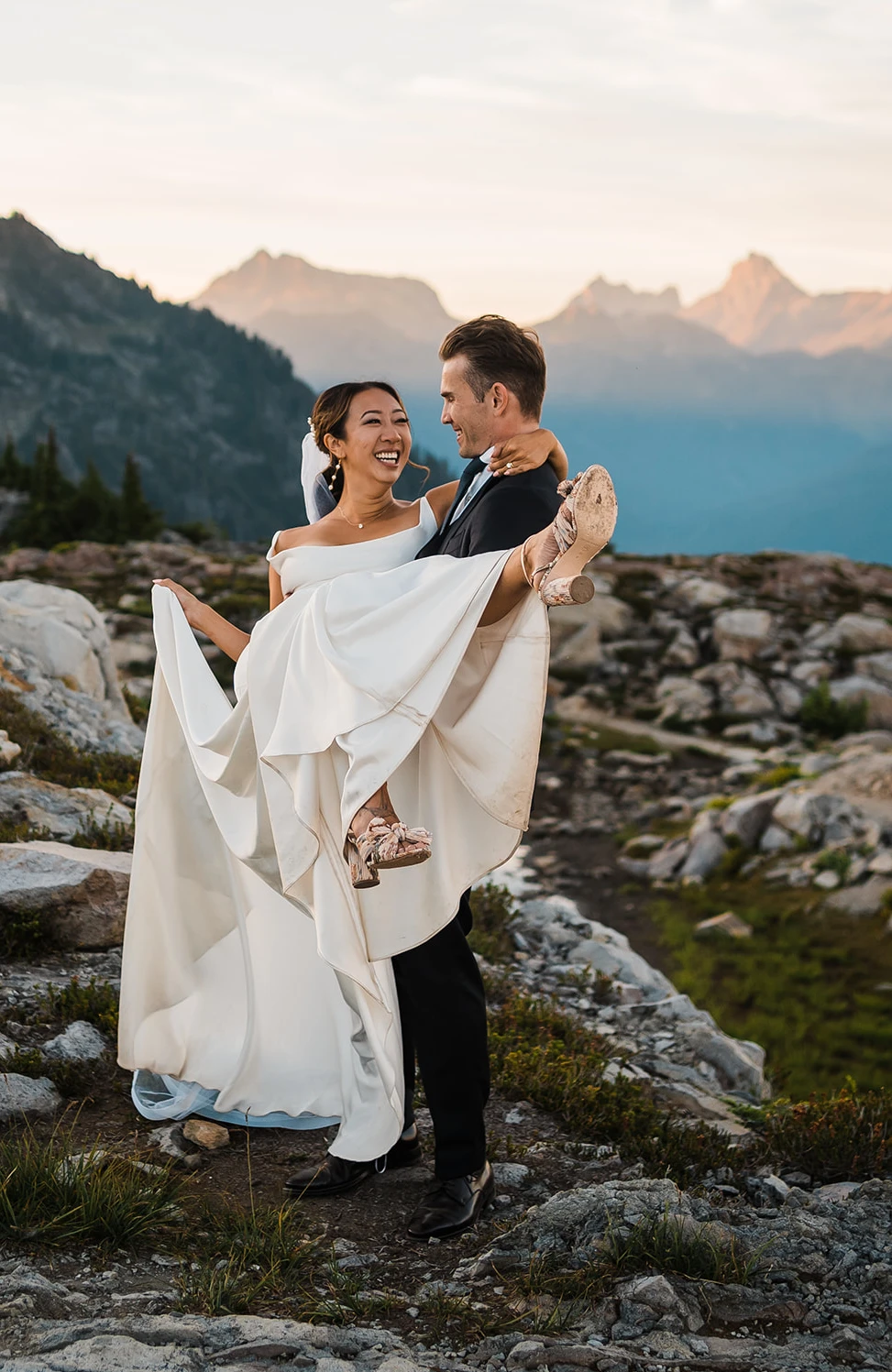 Groom carrying bride on mountainside